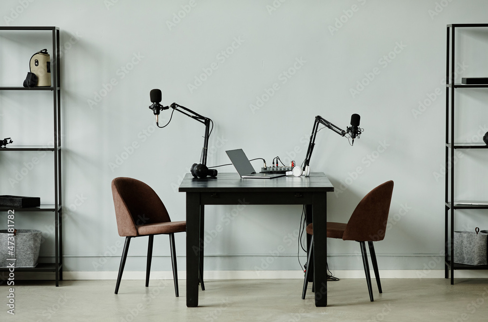 Minimalist podcast studio with two microphones and chairs